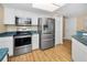 Modern kitchen with stainless steel appliances, white cabinets, and countertops at 1028 Rosetree Ln, Tarpon Springs, FL 34689