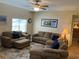 Bright living room featuring cozy seating, a large window, and views into the adjacent hallway at 1028 Rosetree Ln, Tarpon Springs, FL 34689