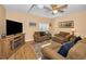 Comfortable living room featuring vaulted ceilings, a fan, and a TV with an electric fireplace at 1028 Rosetree Ln, Tarpon Springs, FL 34689