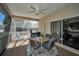 Screened patio with ceiling fan, table, chairs, and view of the pool at 1028 Rosetree Ln, Tarpon Springs, FL 34689