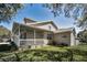 Exterior side view featuring the home's architecture, porch, and manicured lawn at 1028 Rosetree Ln, Tarpon Springs, FL 34689