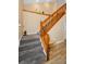 Carpeted staircase with wooden handrail ascending from wood-look flooring, featuring a decorative shelf above at 1028 Rosetree Ln, Tarpon Springs, FL 34689