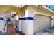 Garage and arched entrance with blue tile accents and an iron gate to the courtyard at 10488 Saint Tropez Pl, Tampa, FL 33615