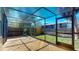 Spacious screened in patio with wood decking and views of the fenced backyard at 10488 Saint Tropez Pl, Tampa, FL 33615