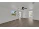 Bright bedroom with a ceiling fan, large window, and modern gray wood-look flooring at 1054 W Baffin Dr, Venice, FL 34293
