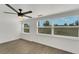 Bright bedroom with a ceiling fan, large windows and modern gray wood-look flooring at 1054 W Baffin Dr, Venice, FL 34293