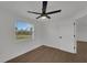 Well-lit bedroom with a neutral palette, ceiling fan, and a bright window overlooking the yard at 1054 W Baffin Dr, Venice, FL 34293