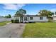 Charming single-story home with a freshly painted exterior, well-manicured lawn, and an inviting black front door at 1054 W Baffin Dr, Venice, FL 34293
