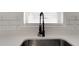 Close-up of a stainless steel sink with quartz countertops and modern black faucet at 1054 W Baffin Dr, Venice, FL 34293