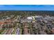Wide aerial view of a condo complex and surrounding area with trees, roads, and nearby shopping center at 1216 S Missouri Ave # 225, Clearwater, FL 33756