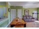 A dining area with wooden table and chairs, light green walls, and a view of the kitchen and living area at 1216 S Missouri Ave # 225, Clearwater, FL 33756