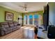 Sunlit living room featuring a large window with shutters, wood floors, a sofa and a flat-screen TV at 1216 S Missouri Ave # 225, Clearwater, FL 33756