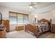 Comfortable bedroom featuring a rattan bed frame, blinds, and ceiling fan at 1400 Water View W Dr # 102, Largo, FL 33771