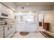 Bright kitchen featuring white cabinets, tile floors, and a breakfast bar opening to the living area at 1400 Water View W Dr # 102, Largo, FL 33771