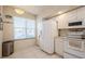 Charming kitchen with white cabinets, appliances, a window, and a stainless trash bin at 1400 Water View W Dr # 102, Largo, FL 33771