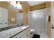 Well-lit bathroom with granite countertop vanity, mirror, shower with decorative curtain and white tiled floors at 1453 Appleton Pl, Wesley Chapel, FL 33543