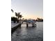 Private dock with a boat, set against a picturesque waterfront and sunset at 16217 Redington Dr, Redington Beach, FL 33708