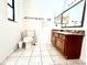 Bright bathroom features tile flooring, wooden cabinets, and a large mirror at 1811 Tawnee Pl, Brandon, FL 33510