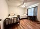 Cozy bedroom with two twin beds, hardwood floors, and a ceiling fan for a comfortable living space at 1811 Tawnee Pl, Brandon, FL 33510