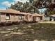 Charming brick home featuring a well-manicured lawn and mature trees, offering a blend of comfort and curb appeal at 1811 Tawnee Pl, Brandon, FL 33510