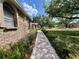 Well-maintained front yard with lush greenery and a paved pathway leading to the home's entrance at 1811 Tawnee Pl, Brandon, FL 33510
