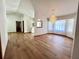 Bright living room with wood flooring, elegant chandelier, and arched doorway leading to foyer at 1811 Tawnee Pl, Brandon, FL 33510