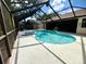Screened-in pool area featuring a sparkling pool, attached spa, and ample space for relaxation at 1811 Tawnee Pl, Brandon, FL 33510