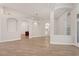 Open-concept living room featuring wood-look tile floors, arched doorways, and a glimpse of the laundry room at 20824 Cedar Bluff Pl, Land O Lakes, FL 34638