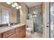 Bathroom with granite vanity, ornate mirror, decorative shower, and frosted glass door at 2307 7Th Sw St, Ruskin, FL 33570