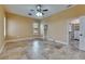 Bedroom featuring travertine floors, tan walls, ceiling fan, and walk-in closet at 2307 7Th Sw St, Ruskin, FL 33570