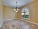 Dining area with travertine floors, arched window with plantation shutters, and chandelier at 2307 7Th Sw St, Ruskin, FL 33570