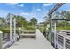 Wooden dock with a bench and boat hoist overlooking the water with lush landscaping and a home in the background at 2307 7Th Sw St, Ruskin, FL 33570