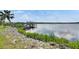 Waterfront with dock, boat lift, and lush greenery at 2307 7Th Sw St, Ruskin, FL 33570