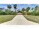 Long private driveway with a gated entrance and lush palm trees, providing an exclusive and grand approach at 2307 7Th Sw St, Ruskin, FL 33570