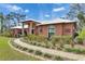 Exterior facade of home showcasing arched windows, professional landscaping, and decorative house numbers at 2307 7Th Sw St, Ruskin, FL 33570