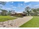 Wide shot of a single-story home featuring a beautiful brick driveway and lush landscaping at 2307 7Th Sw St, Ruskin, FL 33570