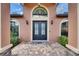Close-up of the home's arched front door with decorative ironwork and manicured landscaping at 2307 7Th Sw St, Ruskin, FL 33570