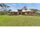 Charming single-story home featuring a well-manicured lawn and vibrant landscaping, complemented by a unique metal roof at 2307 7Th Sw St, Ruskin, FL 33570