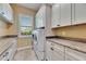 Bright laundry room with tile floors, cabinets and a stacked washer and dryer at 2307 7Th Sw St, Ruskin, FL 33570