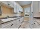 Well-lit laundry room features white cabinetry, granite counters, sink and stacked washer and dryer at 2307 7Th Sw St, Ruskin, FL 33570