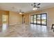 Open living area with travertine floors, ceiling fans, and sliding glass doors leading to the pool at 2307 7Th Sw St, Ruskin, FL 33570