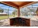 Outdoor bar looking at the screened in pool area with view of the river beyond at 2307 7Th Sw St, Ruskin, FL 33570