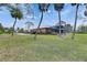 View of the home's screened in lanai, manicured lawn, and mature landscaping at 2307 7Th Sw St, Ruskin, FL 33570