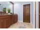 Bathroom features wood cabinets, granite countertops, tile floor with black inlays and modern fixtures at 2709 Fairway View Dr, Valrico, FL 33596
