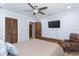 This bedroom features a ceiling fan, hardwood floors, chair, and large flat screen television at 2709 Fairway View Dr, Valrico, FL 33596