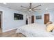 Spacious bedroom featuring an en suite bathroom, a wall-mounted TV, and wood-look flooring at 2709 Fairway View Dr, Valrico, FL 33596