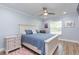 Comfortable bedroom with wood-look floors, ceiling fan, and large window letting in natural light at 2709 Fairway View Dr, Valrico, FL 33596