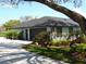Exterior view of home featuring a two car garage, lush landscaping, and a long driveway at 2709 Fairway View Dr, Valrico, FL 33596