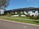 Charming white brick home featuring lush landscaping, solar panels, and a well-manicured lawn at 2709 Fairway View Dr, Valrico, FL 33596