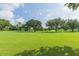 Lush green golf course with mature trees, manicured grass, and clear blue skies on a sunny day at 2709 Fairway View Dr, Valrico, FL 33596